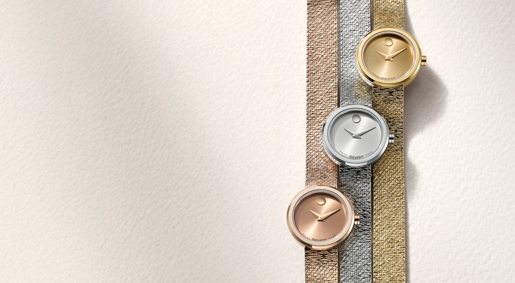 Rose gold tone, stainless steel and gold tone Museum Velura Mini watches laying next to one another.