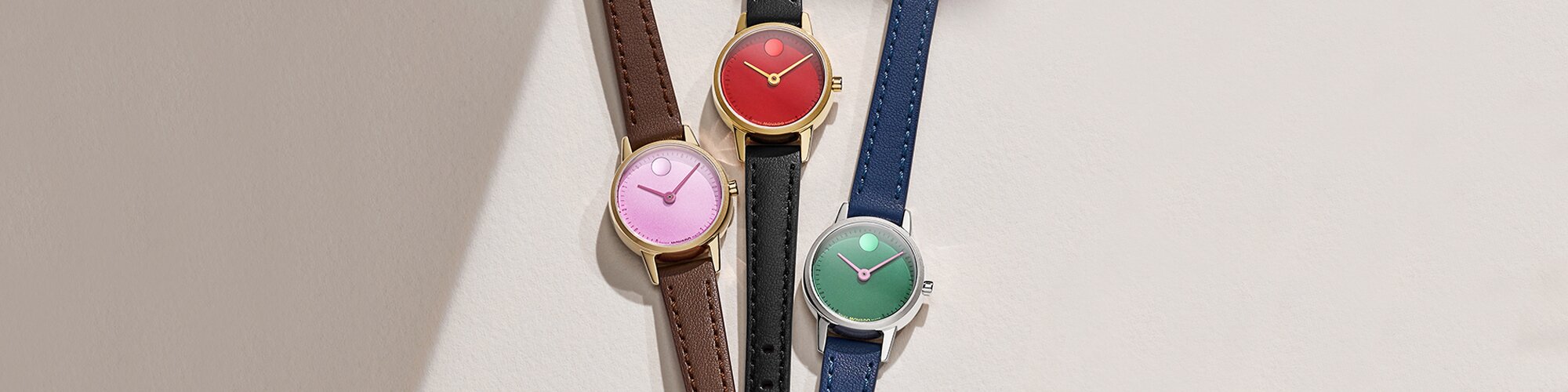 Baby Face watch with brown leather strap and purple dial, next to a Baby Face watch with black strap and red dial, next to a Baby Face watch with blue strap and green dial.