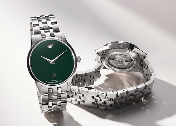 Museum Classic Automatic watch with silver bracelet and green dial next to the back of the watch with an exposed automatic movement case back