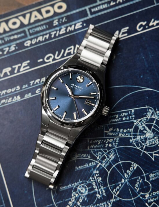 Museum Imperiale Automatic watch with stainless steel bracelet and blue dial laying on top of a blue print of the watch.