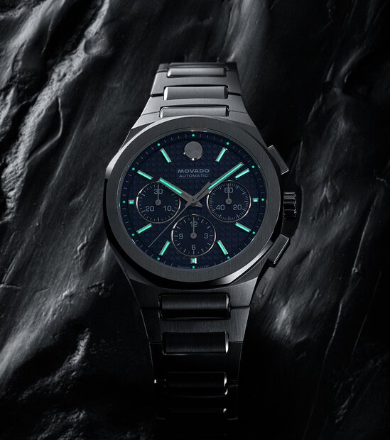 Alta Centurion watch with stainless steel bracelet and blue dial in a dark space with the Swiss Super-LumiNova® accents glowing.