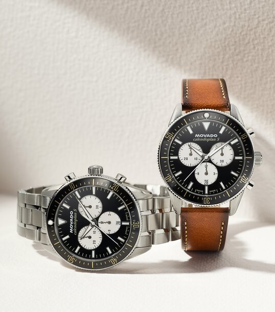 Heritage Calendoplan S watch with stainless steel bracelet and black chronograph dial next to the Heritage Calendoplan S watch with brown leather strap and black chronograph dial.