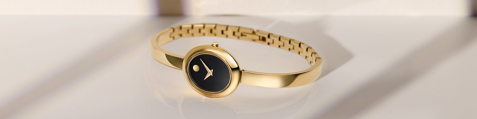Gold tone Museum Bangle watch with black oval dial.