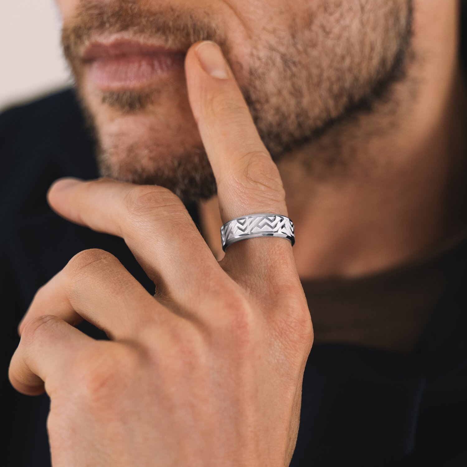 Man leaning on his hand wearing a silver ring.
