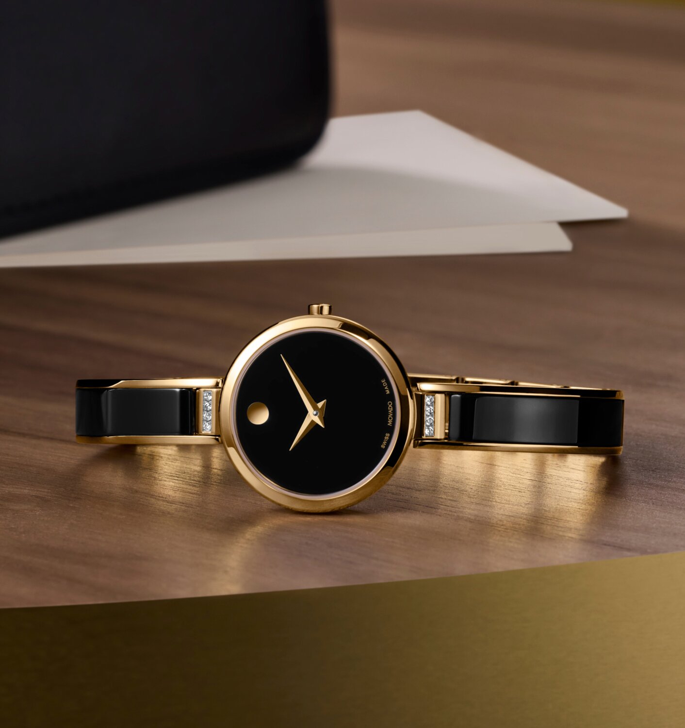 Black Moda Bangle with diamonds laying on a wooden table