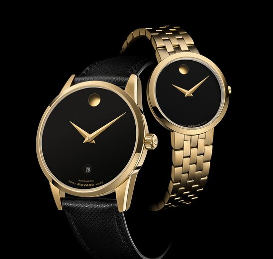 Black Museum Classic watch with strap and gold tone Museum Classic bracelet watch with black dial.