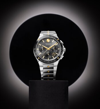 Alta SE Chronograph watch with stainless steel bracelet and black dial and gold accents.