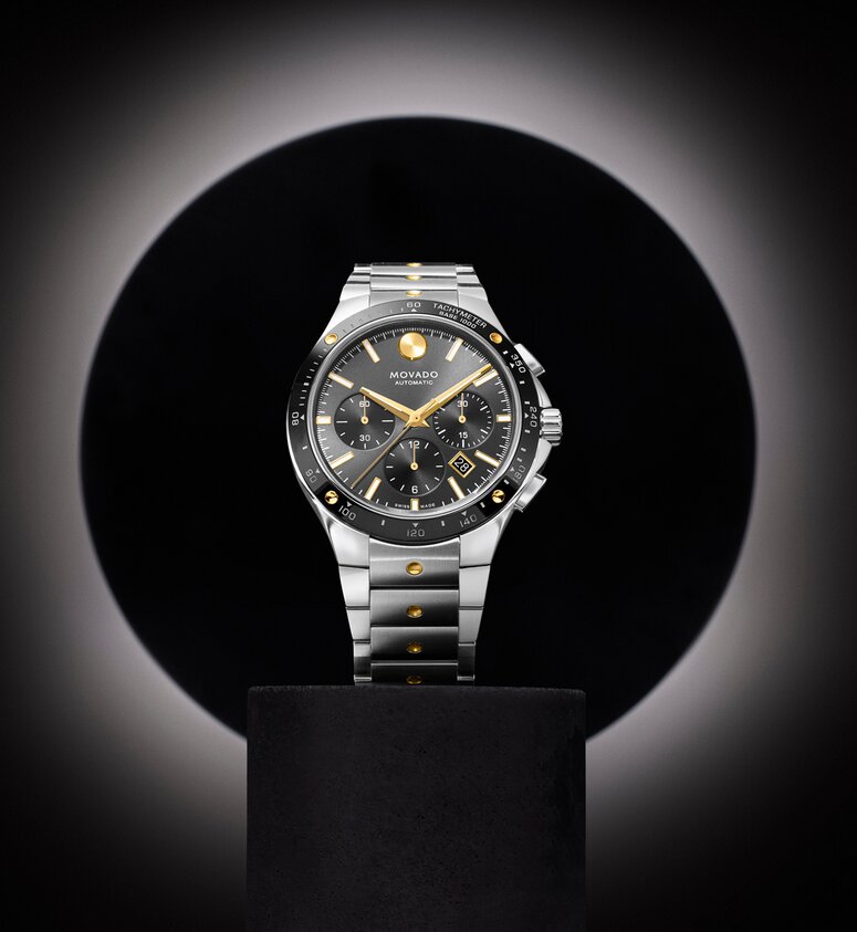Alta SE Chronograph watch with stainless steel bracelet and black dial and gold accents.