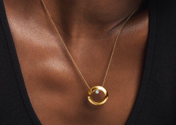 Woman wearing the gold tone Ono Necklace
