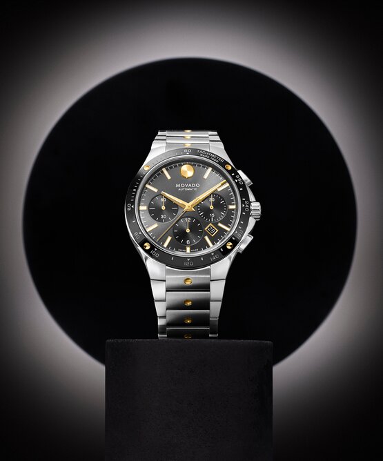 Alta SE Chronograph watch with stainless steel bracelet and black dial and gold accents.