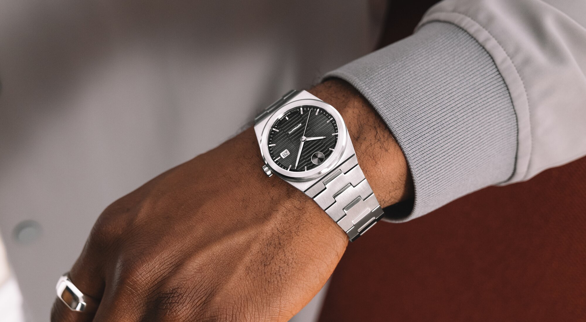 Man in a grey jacket wearing a Movado BOLD Quest Automatic on his wrist.