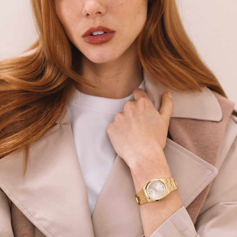 Woman wearing the gold tone BOLD Quest Mini bracelet watch.