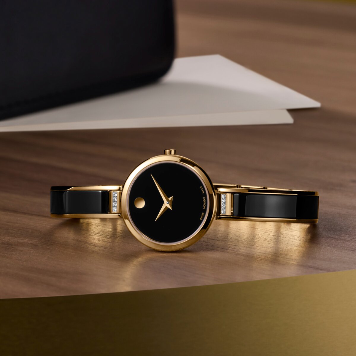 Black Moda Bangle with diamonds laying on a wooden table