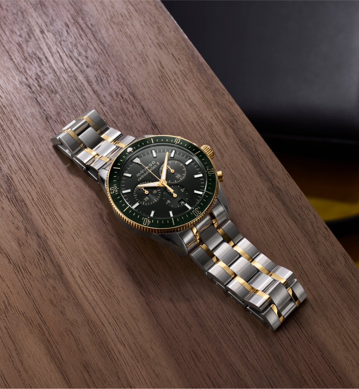 Heritage Series chronograph watch with stainless steel bracelet and green dial laying on a table