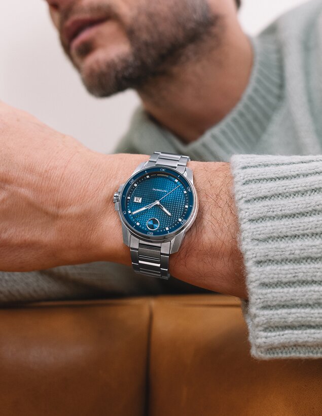Man in a blue sweater wearing the BOLD Verso automatic watch with stainless steel bracelet and blue dial.