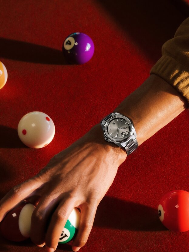 Man wearing the grey BOLD Verso S watch reaching over a pool table.