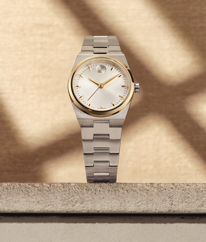BOLD Quest Mini silver watch sitting on a stone slab in front of a tan wall