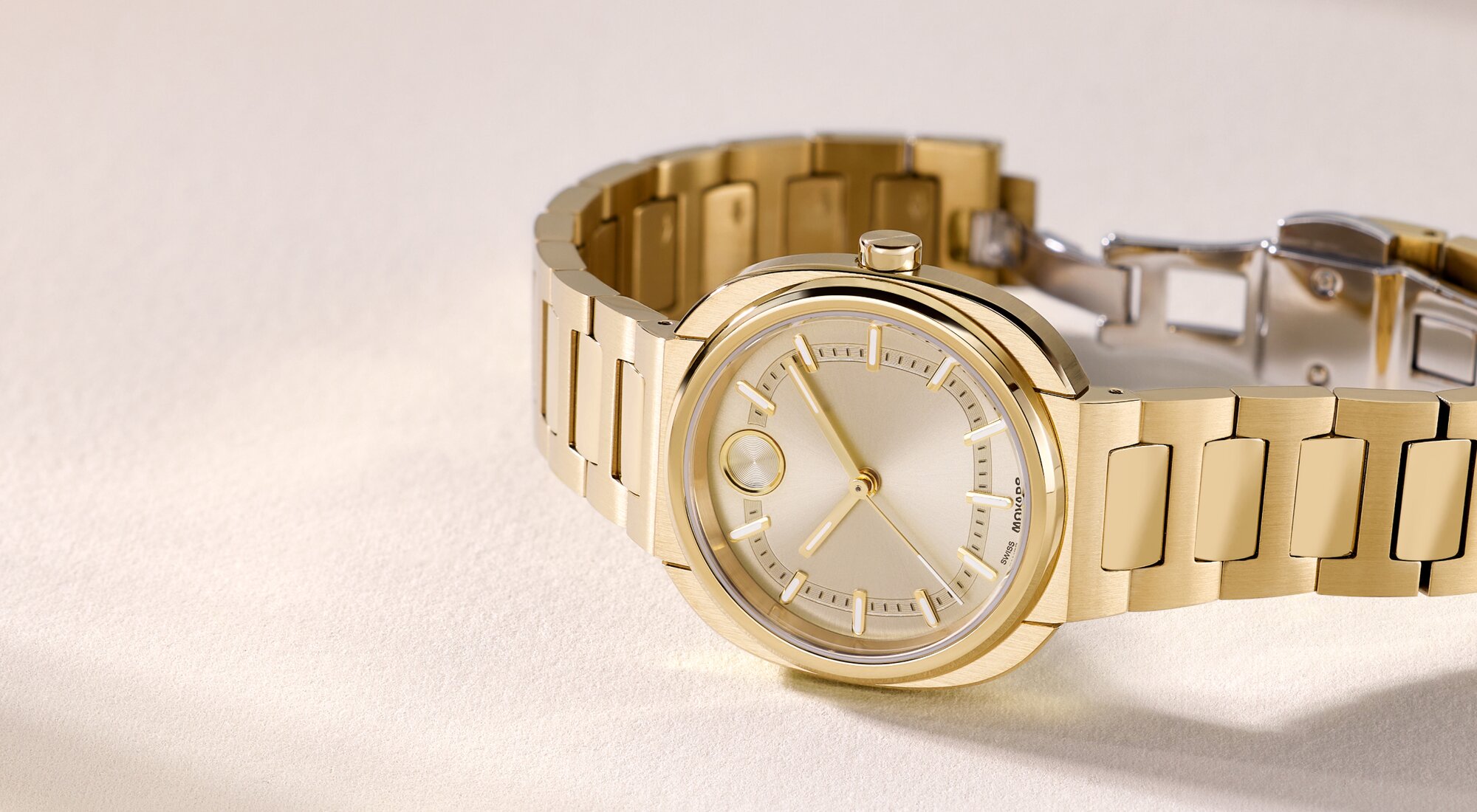 Gold tone BOLD Nuvo bracelet watch laying on its side.
