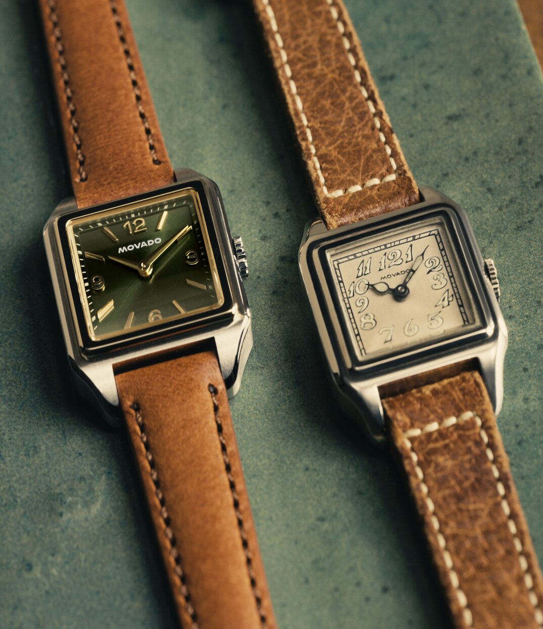 Original Heritage 1917 watch with brown strap and beige dial laying next to the new Heritage 1917 watch with brown strap and green dial.