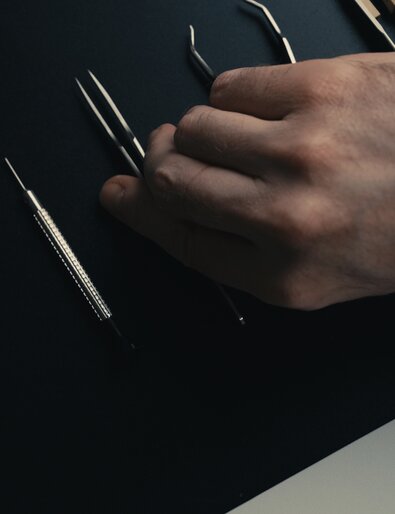 Person grabbing tweezers.