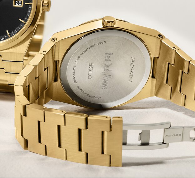 Caseback of gold tone BOLD Quest watch that is engraved with, "Best Dad, Always".