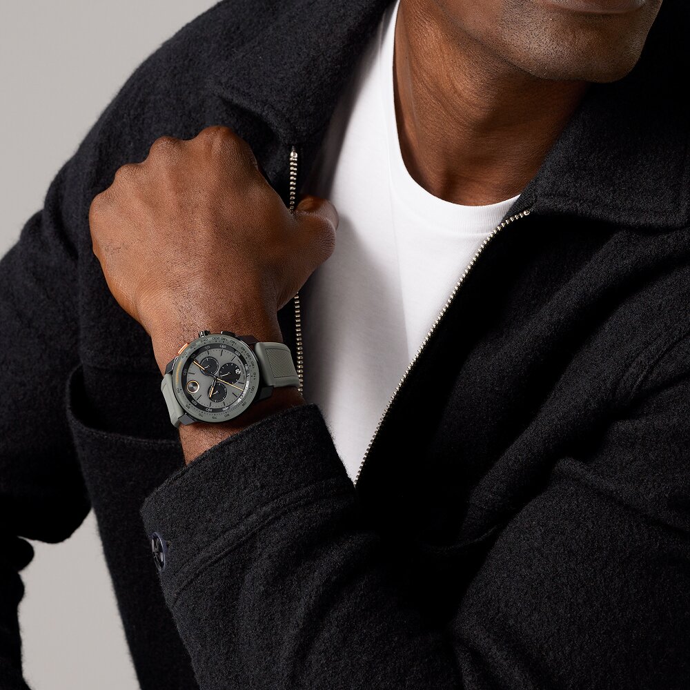 Man in a black cardigan and white shirt wearing the grey TR90 watch with rubber strap and chronograph dial.