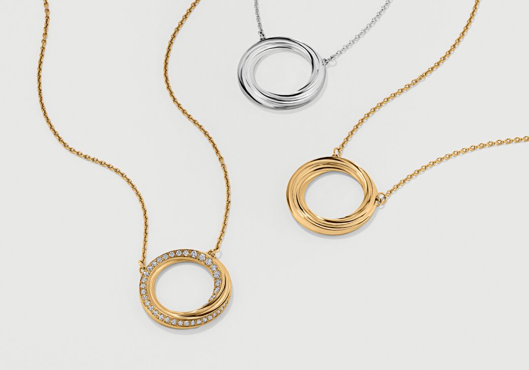 Two gold tone Curve Necklaces and one silver Curve Necklace.