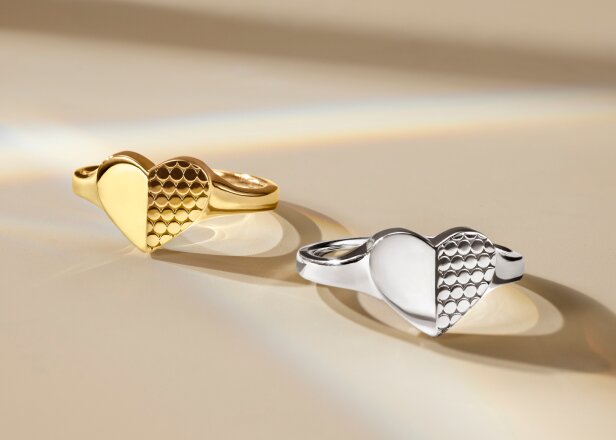 Gold tone heart ring next to silver heart ring