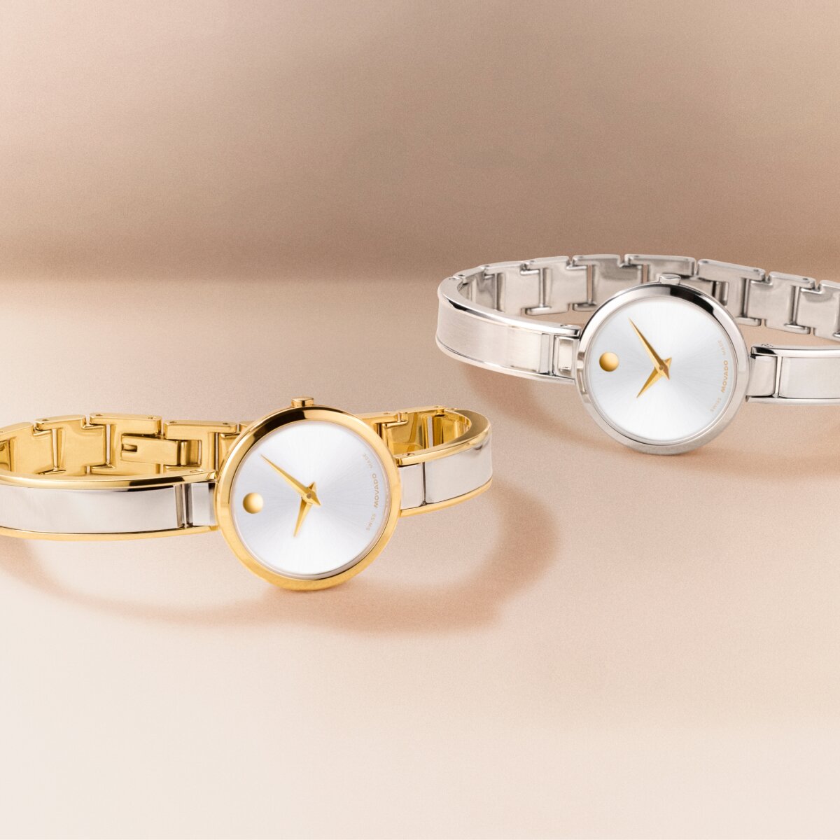 Two tone Moda bangle watch laying in front of a silver Moda bangle watch with gold accents