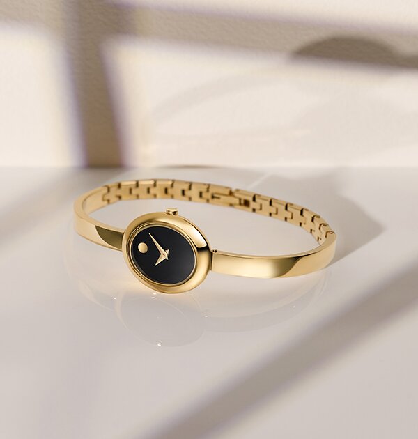 Gold tone Museum Bangle watch with black oval dial.