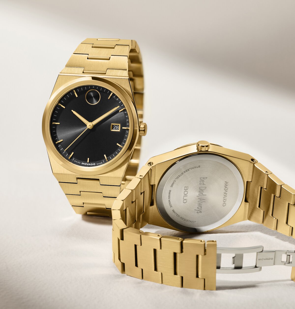 Front and back of a gold tone BOLD Quest bracelet watch with black dial. The caseback features personalized engraving that says, "Best Dad, Always".
