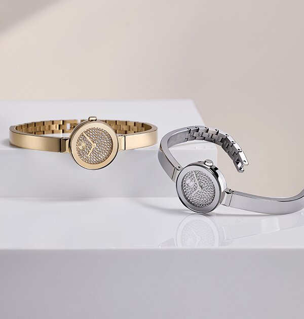 Gold tone and stainless steel BOLD Bangle Mini watches with crystal dials laying next to one another.