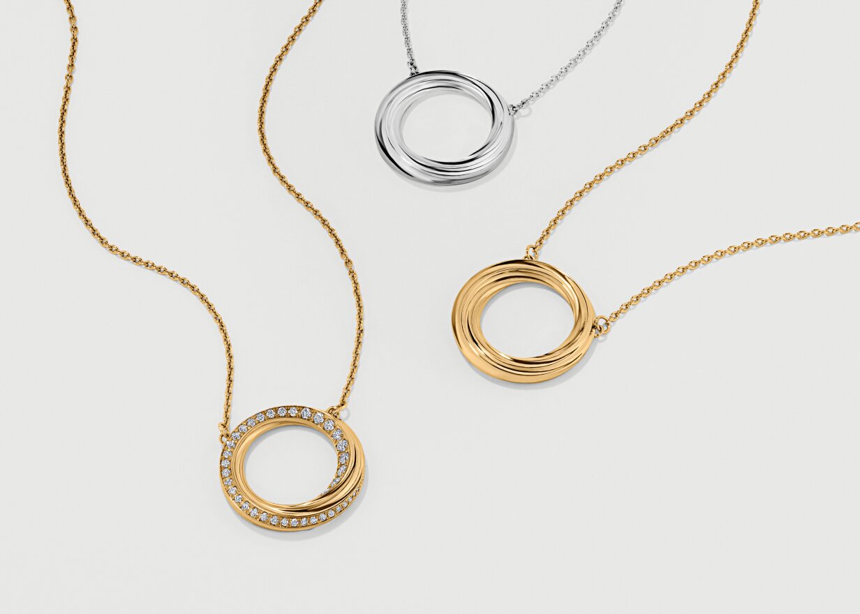 Two gold tone Curve Necklaces and one silver Curve Necklace.