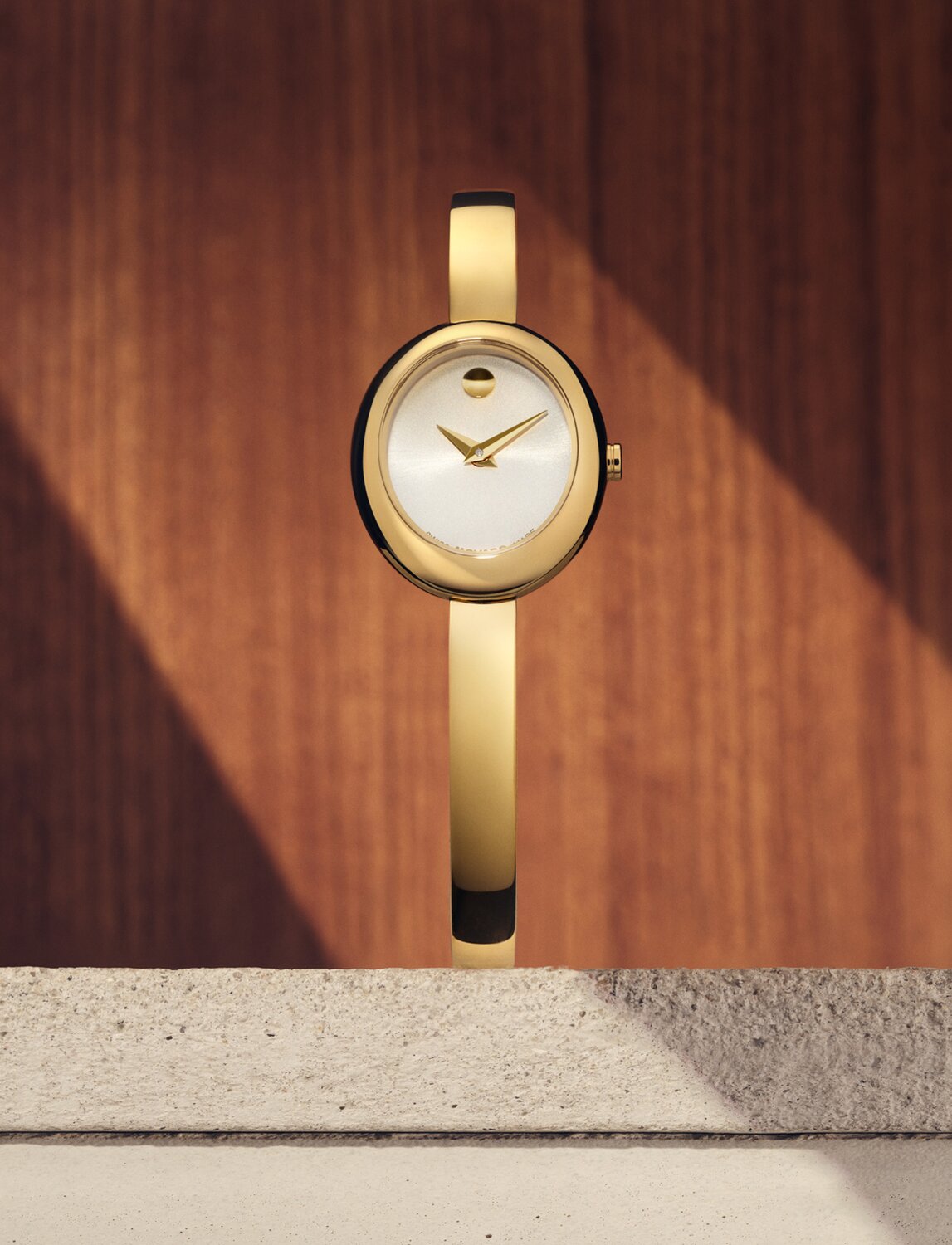 Gold tone Museum Bangle watch with white oval dial.