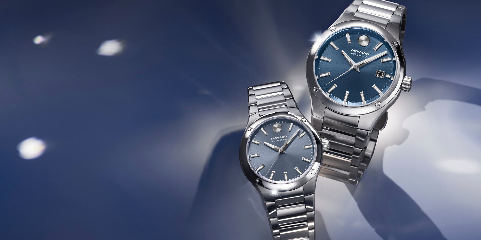 Museum Imperiale Men's watch with stainless steel bracelet and blue dial next to a Museum Imperiale Women's watch with stainless steel bracelet and blue dial.