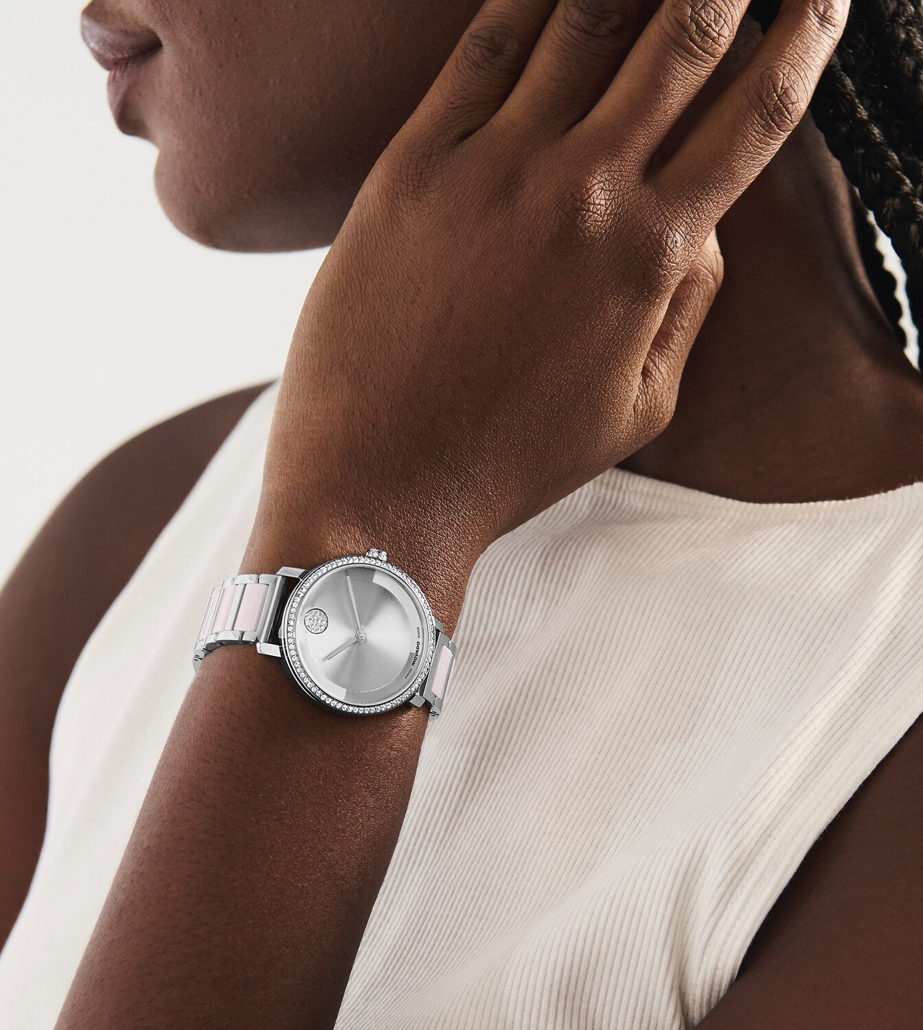 Woman wearing the stainless steel BOLD Evolution 2.0 bracelet watch with pink ceramic center links and crystal bezel.