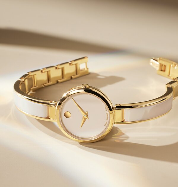 Gold tone Moda bangle watch with taupe ceramic inlay within the bangle and taupe dial.
