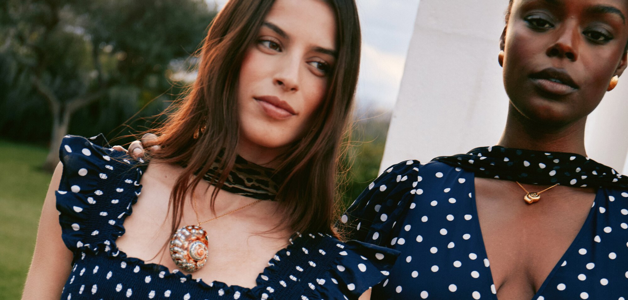 model wearing a navy dress with white polka dots