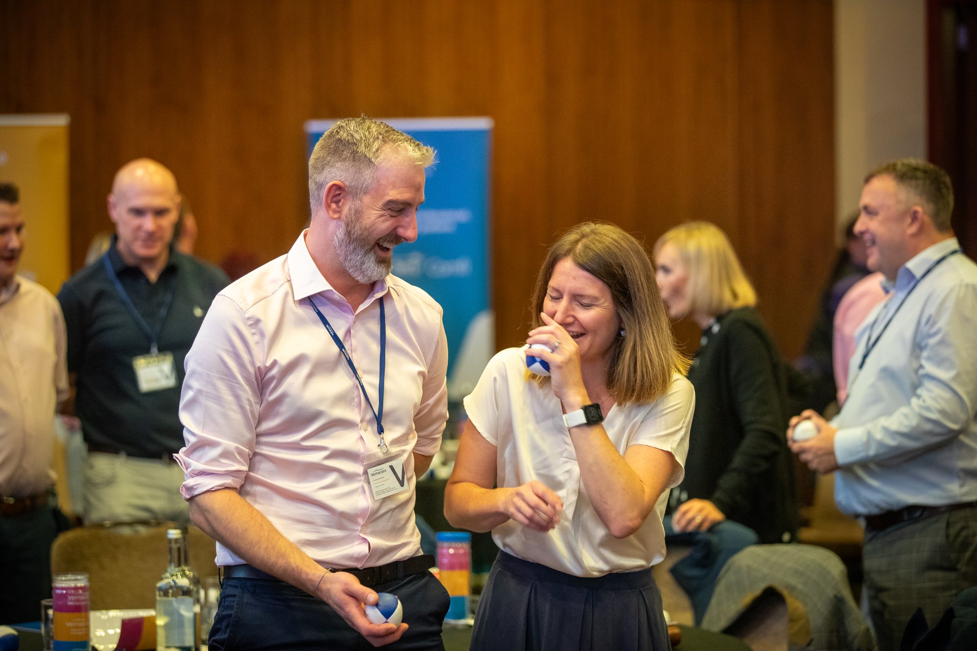 Two colleagues laughing whilst trying to juggle