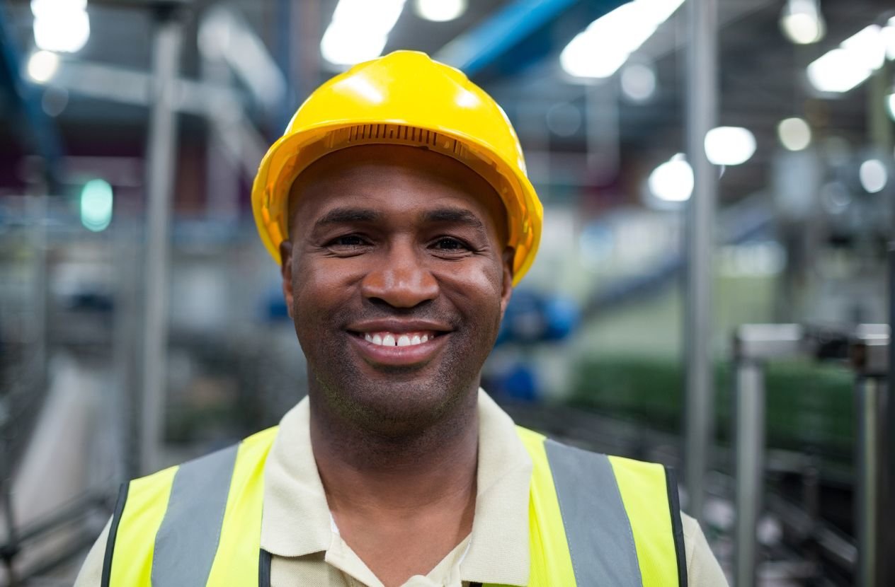 Man smiling at work in a high vis and hard hat