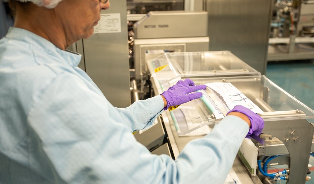 A factory worker inspecting a packet of Conti wet wipes
