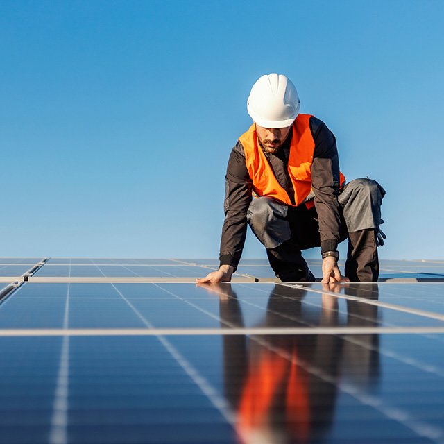 A construction worker fitting solar panels