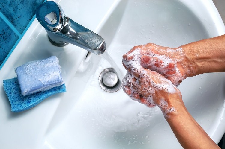 Person washing their hands with soap at a sink