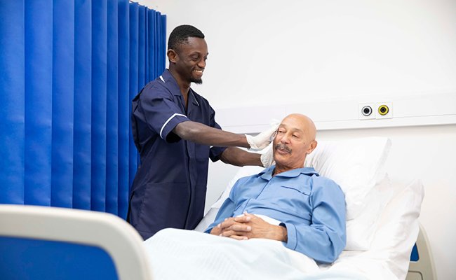 A smiling hospital patient wiping her hands