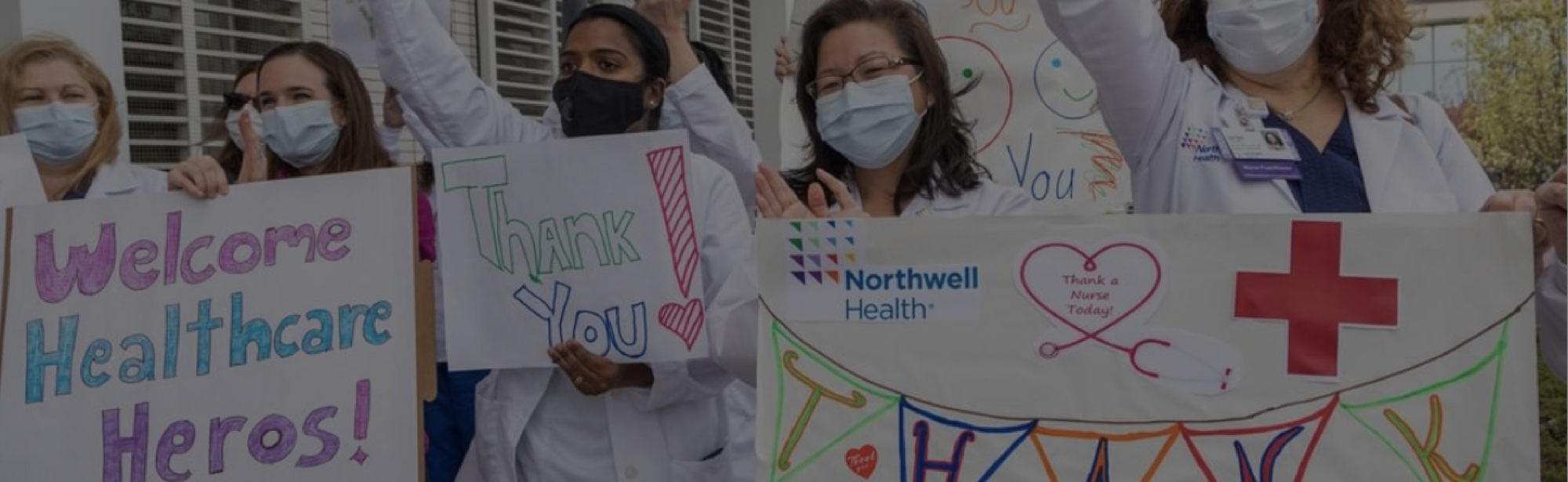 Cross Country color photo of group of healthcare practitioners holding thank you signs. Text reads, "Our Mission".                   