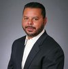 Cross Country color portrait photo of Jerry Chico, VP, Procurement. Jerry is a medium-skin-toned man with short dark hair, mustache, and beard. He is wearing a dark-colored suit coat over a white button-up shirt.           