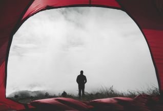 Cross Country color photo of person silhouetted against cloudy sky.             