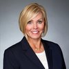 Cross Country color portrait photo of Susan E. Ball, JD, MBA and RN, EVP, General Counsel and Corporate. Susan is a light-skinned woman with chin-length blonde hair. She wears a dark suit coat over a white shirt.                                         