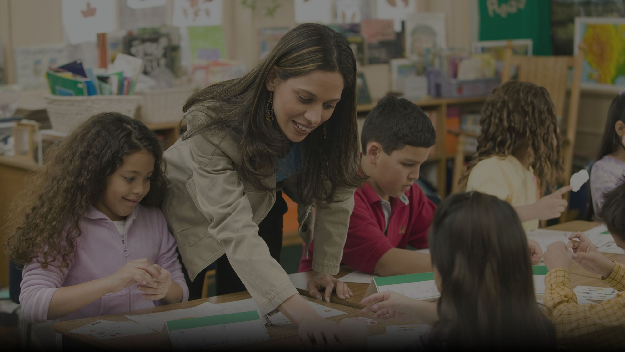 Cross Country Education color photo of a young woman teaching seated students.   