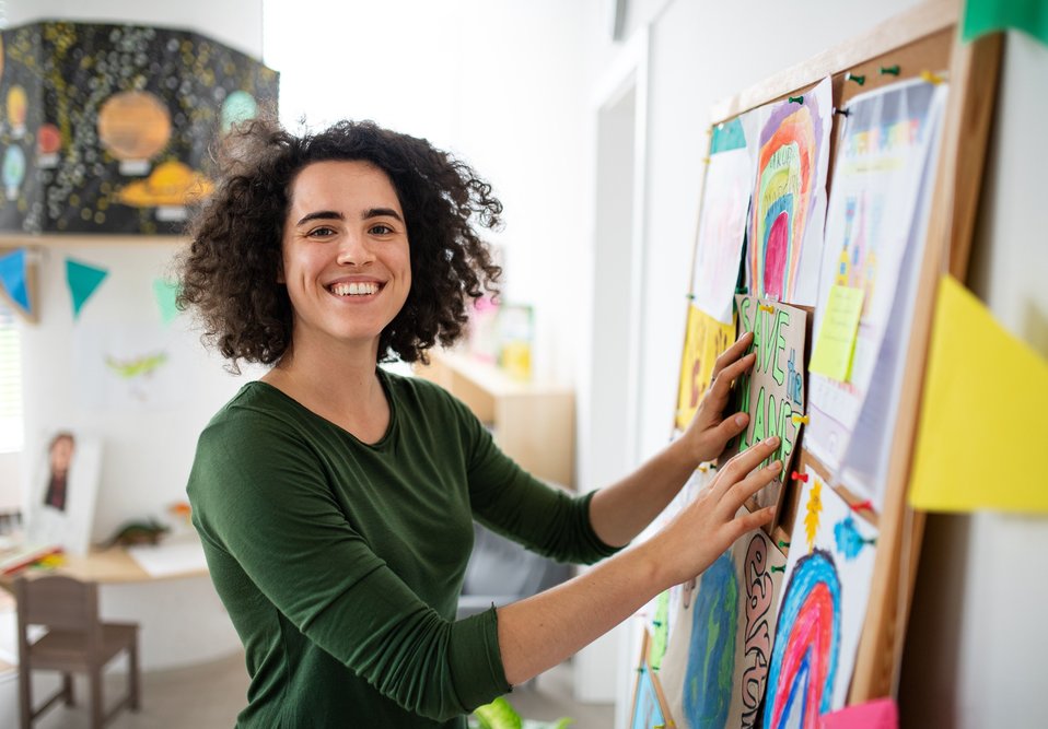 Color photo of young woman working on collage.